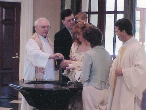 Catie is welcomed into the Church in the Sacrament of Baptism with her parents and Godparents